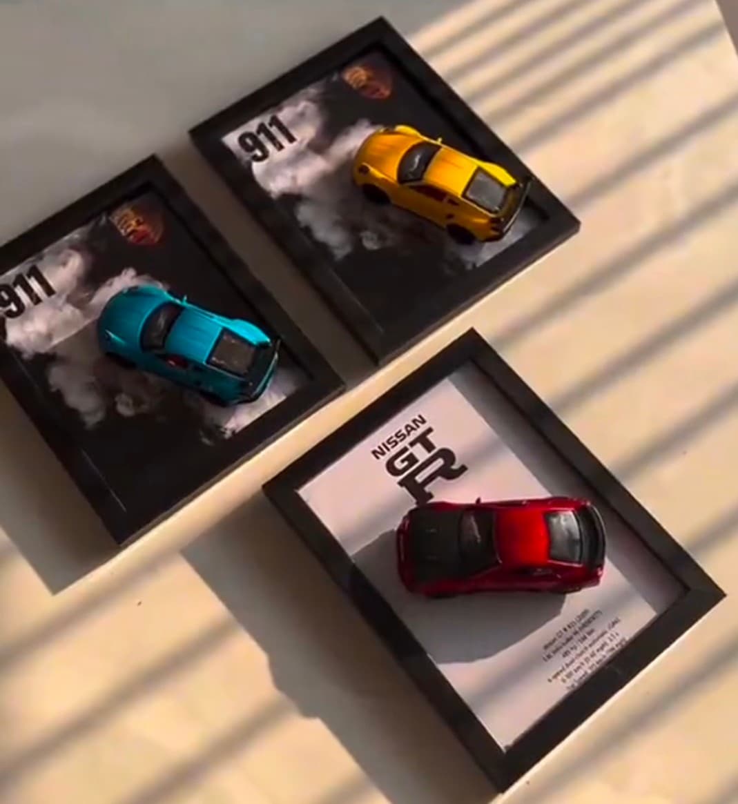 Framed die-cast car build in a garage-wall arrangement